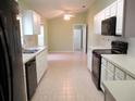 Open kitchen showcasing white cabinets, black appliances, and dining area beyond at 11353 Sw 138Th Ln, Dunnellon, FL 34432
