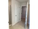 Bathroom with tiled walk-in shower, white door, tile floor and shelving in the walk in closet at 120 Dogwood Drive Cir, Ocala, FL 34472