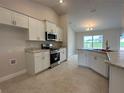 Modern kitchen features white cabinets, granite countertops, stainless steel appliances and tile flooring at 120 Dogwood Drive Cir, Ocala, FL 34472