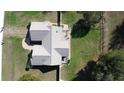 An aerial view of a quaint single-Gathering home with a fenced yard, a deck, and a meticulously maintained roof at 14180 Se 53Rd Ave, Summerfield, FL 34491