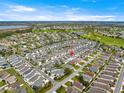 Aerial view of a neighborhood with houses and green spaces surrounding a beautiful pond at 1914 Adair Ln, The Villages, FL 32162