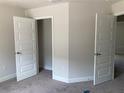 Bright bedroom with neutral walls, carpet, and a closet with stylish double doors at 2 Dogwood Crse, Ocala, FL 34472