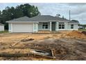 New home exterior with attached garage, light blue paint, and gray shingles on a cloudy day at 2 Dogwood Crse, Ocala, FL 34472