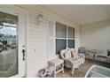 Cozy covered front porch with seating, decorative door and a welcoming ambiance. A perfect spot to unwind at 2538 Privada Dr, The Villages, FL 32162