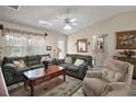 Comfortable living room with plush sofas, a ceiling fan and bright natural light creates a relaxing space at 2538 Privada Dr, The Villages, FL 32162