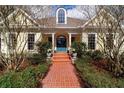 Inviting home entrance features a brick walkway leading to a charming light yellow facade and striking blue-green door at 2775 Sw 53Rd St, Ocala, FL 34471