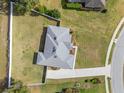 Aerial view of home with light gray roof, manicured lawn, long driveway, and white fence at 5297 Se 39 Loop, Ocala, FL 34480