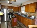 Traditional kitchen with wood cabinets, stainless steel appliances, island, and ample counter space at 55 Sw Fig Tree Ln, Dunnellon, FL 34431