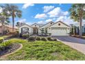 Charming single-story home featuring a well-manicured lawn, brick driveway, two-car garage, and blue sky at 8826 Sw 83Rd Cir, Ocala, FL 34481