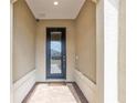 Elegant entryway with textured walls, decorative pillars, and a stylish dark-framed glass door and brick floor at 9581 Sw 63Rd Loop, Ocala, FL 34481