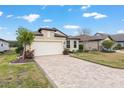 Beautiful one-story home with a brick driveway, lush lawn, and a two-car garage, offering suburban charm at 9581 Sw 63Rd Loop, Ocala, FL 34481