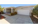 Home featuring a well-maintained driveway and attached garage at 9704 Sw 95Th Loop, Ocala, FL 34481