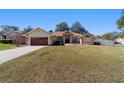 Charming single-story home featuring a well-manicured lawn and an attached two-car garage at 10080 Se 68Th Ct, Belleview, FL 34420