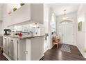 Entryway view showcasing hardwood floors, white walls, an arched doorway and access to the kitchen at 11221 Sw 71St Ct, Ocala, FL 34476