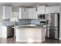 Modern kitchen featuring white cabinets, stainless steel appliances, granite countertops, and an island at 12164 Se 85Th Ct, Belleview, FL 34420