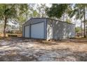 Outbuilding with two garage doors and a side door perfect for a workshop or extra storage at 12330 Sw 43 St Rd, Ocala, FL 34481