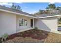 Inviting front entrance with freshly landscaped garden and a modern black front door at 14 Water Track Ct, Ocala, FL 34472