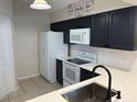 Modern kitchen with stainless steel appliances, white countertops, and dark cabinets at 1917 Nw 50Th Cir, Ocala, FL 34482