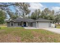 Charming single-story home with a well-manicured lawn, stone accents and a two-car garage at 2045 Marion County Rd, Weirsdale, FL 32195