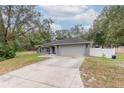 Charming single-story home with a well-manicured lawn, stone accents and a two-car garage at 2045 Marion County Rd, Weirsdale, FL 32195