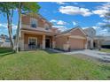 Charming two-story home with front yard, covered porch, and two-car garage at 3999 Sw 51St Ct, Ocala, FL 34474