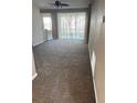 Living room with carpet flooring and a sliding glass door at 4525 Sw 52Nd Cir # 105, Ocala, FL 34474