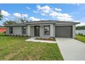 Front view of a charming home with a well-kept lawn and a gray exterior at 540 Nw 64Th Pl, Ocala, FL 34475