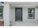 Close-up of the home's front door, flanked by windows at 540 Nw 64Th Pl, Ocala, FL 34475