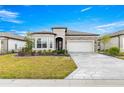 Beautiful front exterior featuring stone accents, a well-manicured lawn and an eye catching driveway at 5728 Sw 90Th Court Rd, Ocala, FL 34481