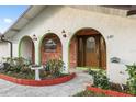 Close-up of the home's inviting arched entryway framed by brick accents and greenery at 711 Se 26Th St, Ocala, FL 34471