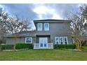 Two-story home with a well-maintained lawn, shuttered windows, and a charming balcony at 8135 Nw 26Th Lane Rd, Ocala, FL 34482