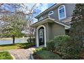 Lovely home exterior with lush landscaping, arched windows, and lake view in the background at 8135 Nw 26Th Lane Rd, Ocala, FL 34482