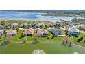 Aerial view of the community featuring well-manicured lawns, lake, and the neighborhood homes at 10138 Lake Miona Way, Oxford, FL 34484