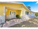 Charming yellow home featuring a welcoming front porch and well-manicured landscaping at 11620 Sw 84Th Avenue Rd, Ocala, FL 34481