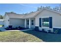 Well-maintained home showcasing a manicured lawn, mulched garden, and a covered entryway at 13936 Sw 113 Ln, Dunnellon, FL 34432