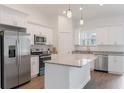 Bright kitchen showcasing white cabinetry, granite countertops, stainless steel appliances, and pendant lighting at 14404 Sw 19Th Pl, Ocala, FL 34481