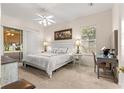 Bright bedroom with neutral colors, large window, ceiling fan, and a decorative writing desk at 2310 Nw 59Th Ave, Ocala, FL 34482