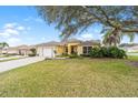 Charming single Gathering home with a two-car garage, a well-manicured lawn and a large tree at 3001 Rugby Way, The Villages, FL 32162