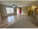 Inviting living room featuring hardwood floors, a ceiling fan, and a bright red front door at 3044 Sw 168Th Loop, Ocala, FL 34473