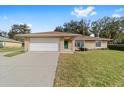 Single-story home featuring a well-manicured lawn, driveway, and an attached two-car garage at 4837 Ne 5Th Street Rd, Ocala, FL 34470