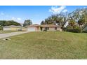 Single-story home featuring a well-manicured lawn, driveway, and an attached two-car garage at 4837 Ne 5Th Street Rd, Ocala, FL 34470