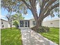 Charming single-story home featuring a concrete driveway and well-maintained lawn at 615 Ne Cottage Park Ln, Leesburg, FL 34748