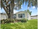 Charming single-story home featuring a well-maintained lawn and beautiful landscaping at 615 Ne Cottage Park Ln, Leesburg, FL 34748