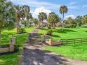 Estate entrance featuring a gated driveway and lush, manicured landscaping at 6994 Nw 320 Hwy, Micanopy, FL 32667