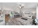 Bright, open living room with a vaulted ceiling, ceiling fan, bar seating and stylish decor flowing into the dining area at 8164 Sw 131St Pl, Ocala, FL 34473