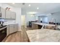 Open kitchen with granite countertops, stainless steel sink, and gray cabinets at 9105 Se 55Th Ter, Ocala, FL 34480