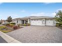 Spacious home featuring a three-car garage and a brick-paved driveway at 9270 Sw 89Th Street Rd, Ocala, FL 34481