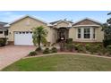 Inviting single-story home featuring a lush front yard with colorful flowers and a brick-paved walkway to the entrance at 9274 Sw 94Th Loop, Ocala, FL 34481