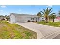 Charming single-story home with paver driveway, well-manicured lawn, beautiful landscaping, and a two-car garage at 9750 Se 179Th Pl, Summerfield, FL 34491