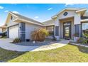 Close up of the house entrance showing front door, landscaping, and two car garage at 10100 Se 69Th Ave, Belleview, FL 34420